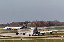 An Atlas Air Boeing 747-8F lines up on Runway 27 at Cincinnati/Northern Kentucky International Airport as one of the airline's 747-400Fs lands on Runway 18C.